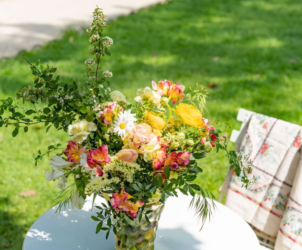 Bouquet de printemps posé sur une table de jardin, sur la pelouse